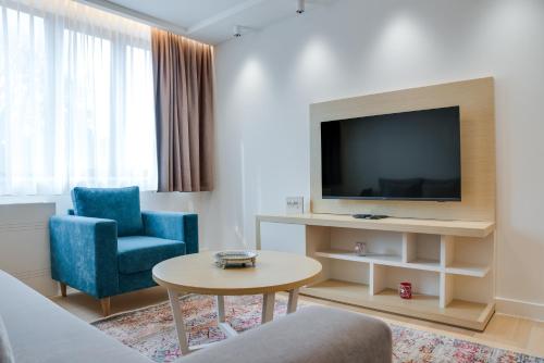 a living room with a tv and a couch and a table at Apartmani Zepterme by CENTRAL in Vrnjačka Banja