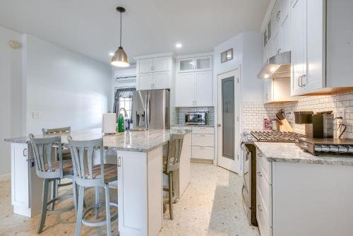 a kitchen with white cabinets and a island with bar stools at 4 Mi to Lake Logan Hocking Hills Apartment in Logan