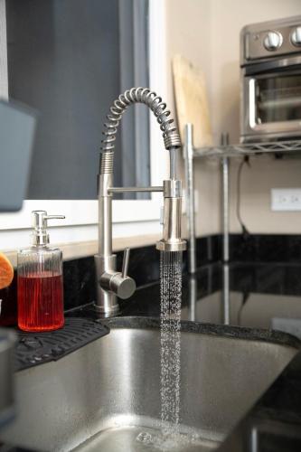 a kitchen sink with water coming out of a faucet at Townhouse - Centrico - Modern - 3 hab - Patio in San Pedro Sula