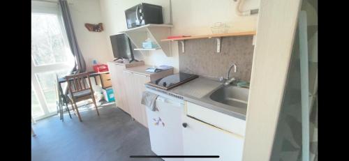 une petite cuisine avec un évier et un comptoir dans l'établissement Le petit Studio, à Saint-Nazaire
