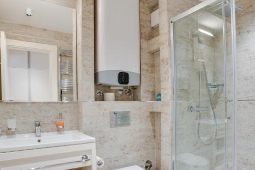 a bathroom with a sink and a shower at Apartmani Zepterme by CENTRAL in Vrnjačka Banja