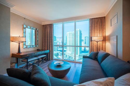 a living room with a couch and a large window at No Resort Fee Strip View Suite + Free Valet + Pool in Las Vegas