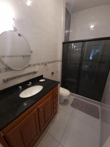 a bathroom with a sink and a mirror and a toilet at Apê com 2 quartos super bem localizado em copa in Rio de Janeiro