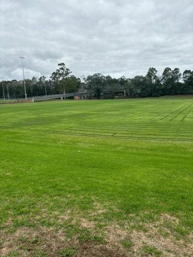 a large green field with trees in the background at New stand-alone 2-bedroom house in Baulkham Hills