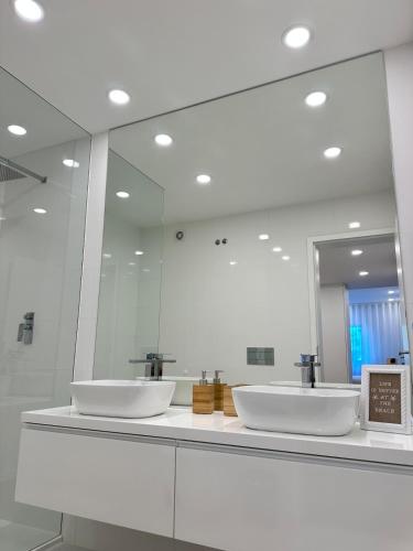 a bathroom with two sinks and a large mirror at Costa Nova Premium Apartment & Pool in Costa Nova
