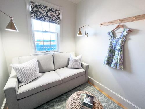 a living room with a couch and a dress hanging on a wall at Nantucket Resort Collection in Nantucket