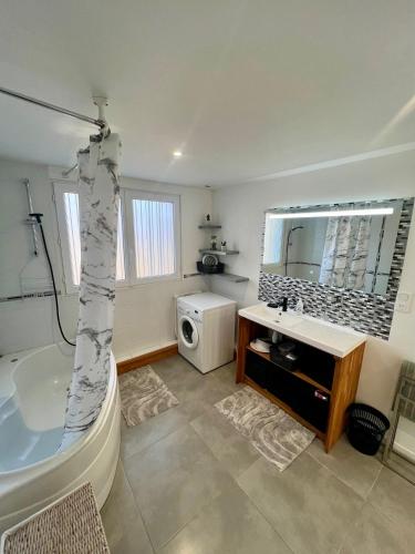 une salle de bain avec une baignoire, un lavabo et un miroir dans l'établissement Grand apt La Bresse 6 a 8 pers centre et pistes proches, à La Bresse