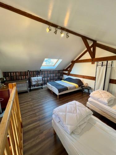 a attic room with two beds and a library at Grand apt La Bresse 6 a 8 pers centre et pistes proches in La Bresse