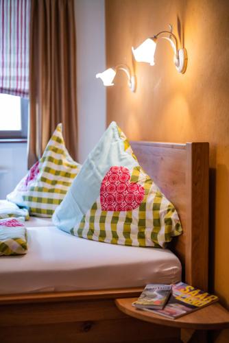 a bed with two pillows and a table with a lamp at Landhaus Wern's Mühle in Ottweiler