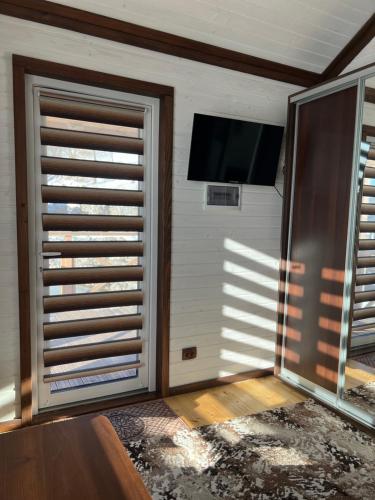 a room with a sliding door with a tv on the wall at Готельно-Ресторанний комплекс Кичера in Volovets
