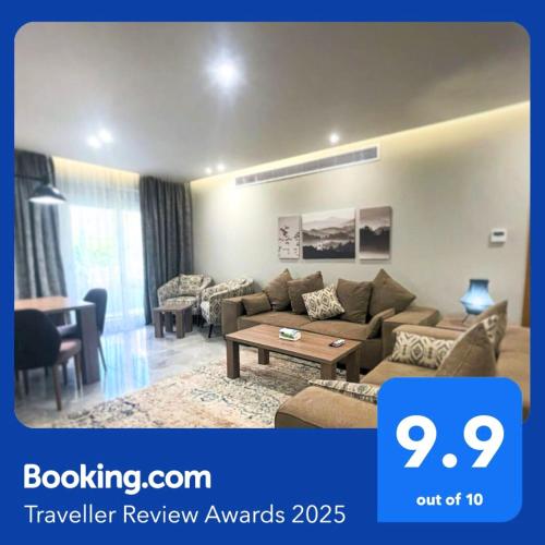 a living room with a couch and a table at شقة فاخرة 3 غرف نوم و حديقة خاصة في الشيخ زايد - Zayed Suites A in Sheikh Zayed