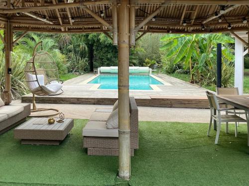 - une piscine avec une chaise, une table et un parasol dans l'établissement Le cottage des îles, à Cépet
