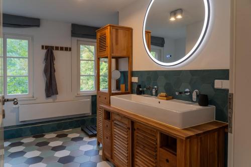 a bathroom with a large sink and a mirror at Wald- und Seeidyll im historischen Forsthaus in Neuruppin