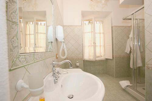 een badkamer met een wastafel en een spiegel en een douche bij Sleep In Rome Ludovisi in Rome