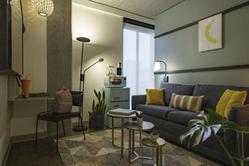 a living room with a couch and a table at Moxy Portland Downtown in Portland