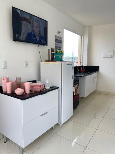 a kitchen with white cabinets and a refrigerator at Paraíso á beira mar in Lauro de Freitas