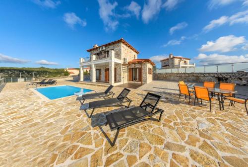 a villa with a pool and chairs and a house at Orient Villas Volimes in Volímai