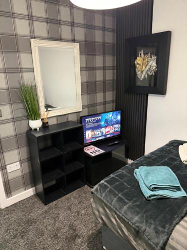 プレストンにあるMoor Park Apartmentsのベッドルーム(ベッド1台、鏡、テレビ付)