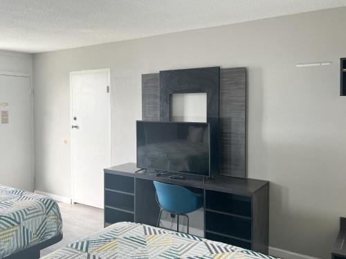 a bedroom with a bed and a desk with a television at Motel 6 Lugoff, SC in Lugoff