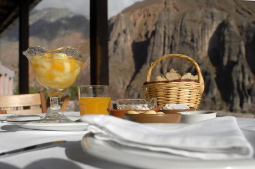 伊魯亞的住宿－Hotel Iruya，一张桌子,上面放着一篮子的食物和一杯橙汁