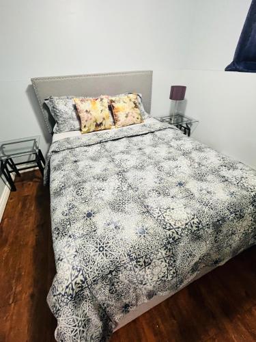 a bedroom with a bed with a black and white comforter at Basement unit with 2 bedrooms, bath and living area in Lower Sackville