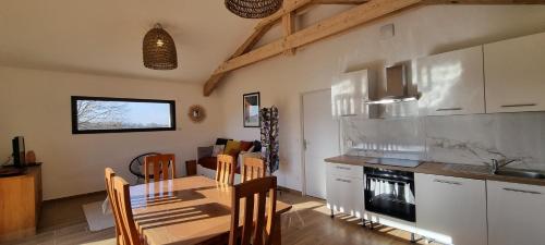 une cuisine et une salle à manger avec une table et des chaises dans l'établissement Gite face au Vercors, à Marches