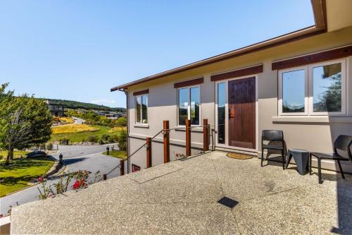 a house with a balcony with a view of a street at Studio Nestled in Ridgecrest in Wanaka