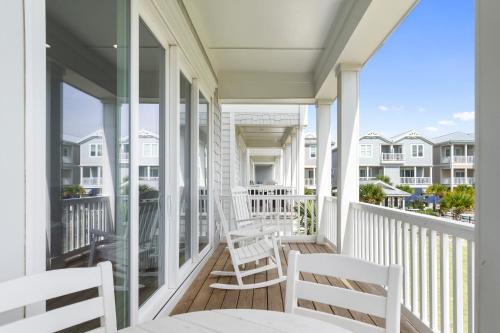 a white porch with two chairs and a table at Luxury Th In Emerald Isle, Nc Welevator in Emerald Isle