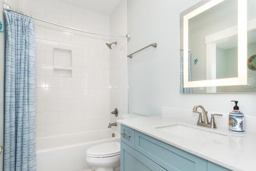 a bathroom with a sink and a toilet and a mirror at Luxury Th In Emerald Isle, Nc Welevator in Emerald Isle