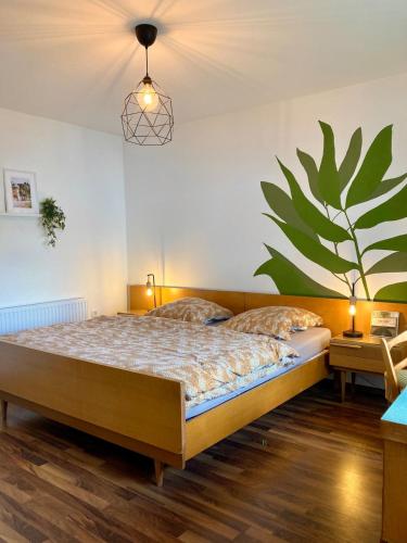 a bedroom with a bed with a large plant on the wall at Senne Bungalow in Augustdorf