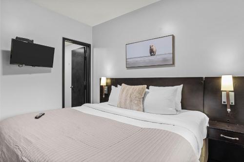 a bedroom with a large white bed and a tv at Outstanding Mountain Condo WATERSLIDE and HOT TUB managed by Little Sister Getaways in Canmore