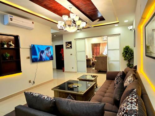 a living room with a couch and a tv at Opulent 5-BHK Entire House in Bahria Town Phase 3 in Rawalpindi