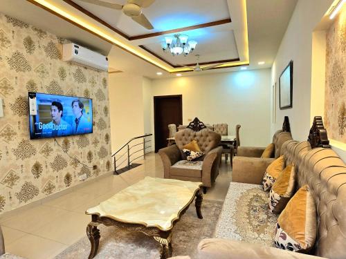 a living room with a couch and a tv on the wall at Opulent 5-BHK Entire House in Bahria Town Phase 3 in Rawalpindi