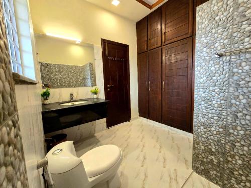 a bathroom with a toilet and a sink and a mirror at Opulent 5-BHK Entire House in Bahria Town Phase 3 in Rawalpindi