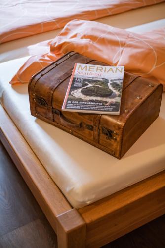 a wooden box sitting on top of a bed at Landhaus Wern's Mühle in Ottweiler
