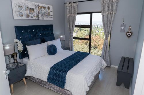 a bedroom with a large bed with a large window at Grandview Guesthouse in Cape Town
