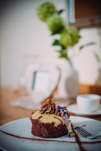 a piece of cake on a plate on a table at Landhaus Wern's Mühle in Ottweiler