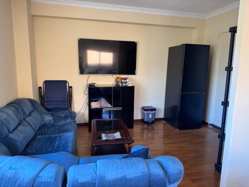 a living room with a blue couch and a flat screen tv at Casa Monsenhor in Braga