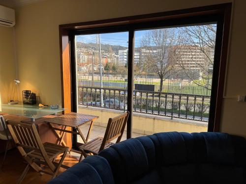 a living room with a table and chairs and a large window at Casa Monsenhor in Braga
