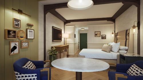 a hotel room with a bed and a table and chairs at Delamar Mystic in Mystic