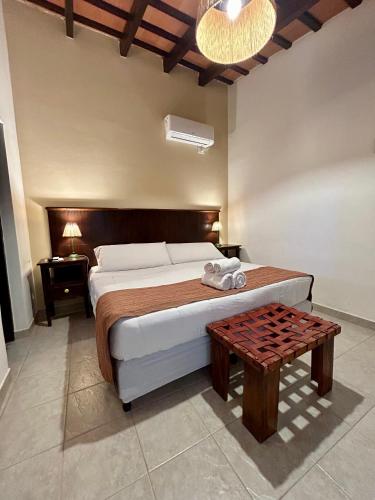 a bedroom with a bed and a table at Hotel Plaza Cafayate in Cafayate