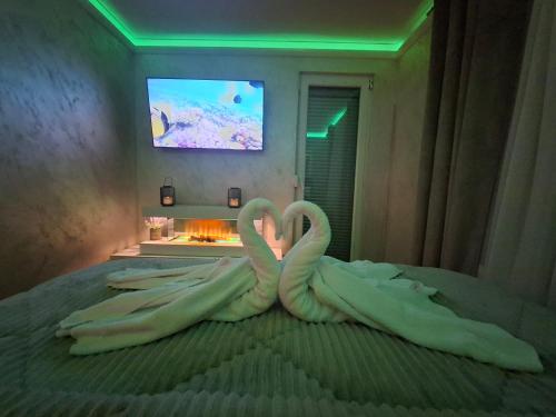 two swans making a heart on a bed at Royal Place Apartment - East Sarajevo in Lukavica