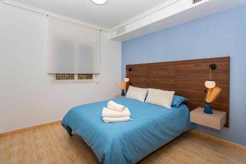 a bedroom with a blue bed with two white pillows at Villa Deva 20 in Torrevieja