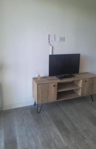 a wooden entertainment center with a flat screen tv on it at Ale-MardelPlata-Sicilia in Mar del Plata