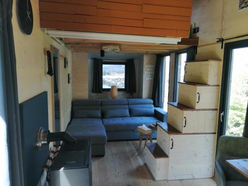 ザンクト・マルグレーテンにあるTiny House im Grünenの小さな家のリビングルーム(青いソファ付)