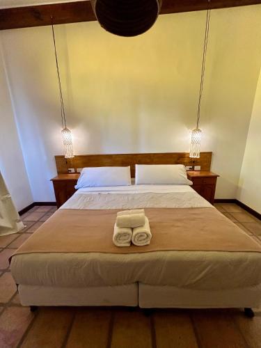 a bedroom with a bed with two towels on it at Hotel Plaza Cafayate in Cafayate