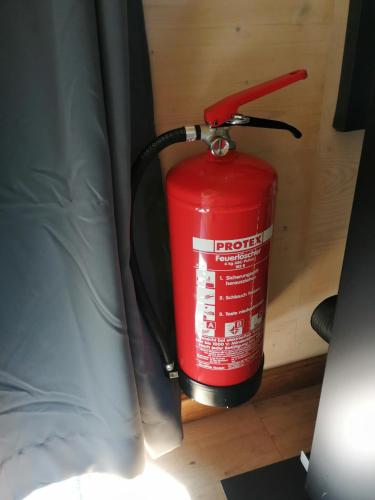 a red fire hydrant sitting next to a bed at Tiny House im Grünen in Sankt Margrethen
