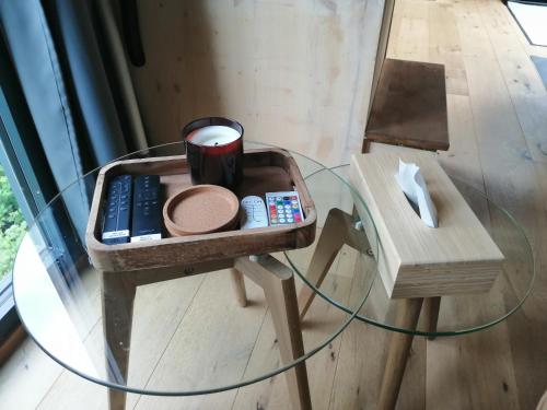 a glass table with a tray on top of a table with a glass tableasonable at Tiny House im Grünen in Sankt Margrethen