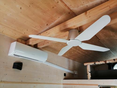 a ceiling fan in a room with wooden ceilings at Tiny House im Grünen in Sankt Margrethen