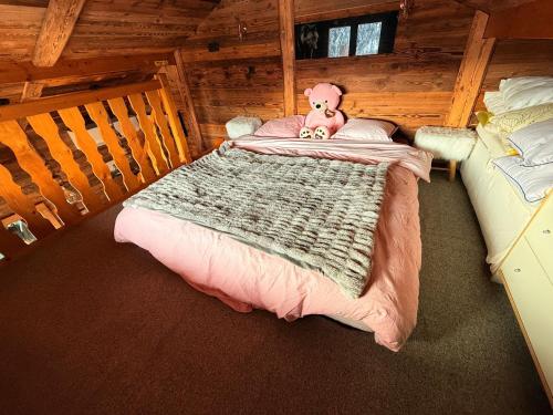 een slaapkamer met een bed met een teddybeer erop bij Chalet Cosy Les Gets Vue Montagne in Les Gets
